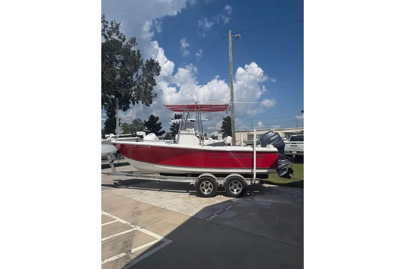 Slide: The Image of 2010 Sea Hunt Triton 202 boat on trailer, red and white, parked outdoors. - 5