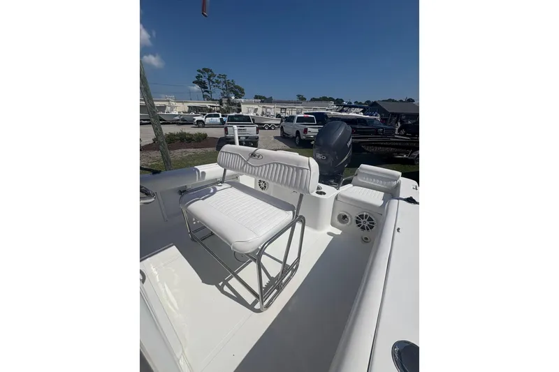 Slide: The Image of 2010 Sea Hunt Triton 202 boat interior with seating and motor, parked outdoors. - 7