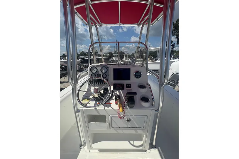 Slide: The Image of 2010 Sea Hunt Triton 202 boat console with steering wheel and gauges under red canopy. - 8