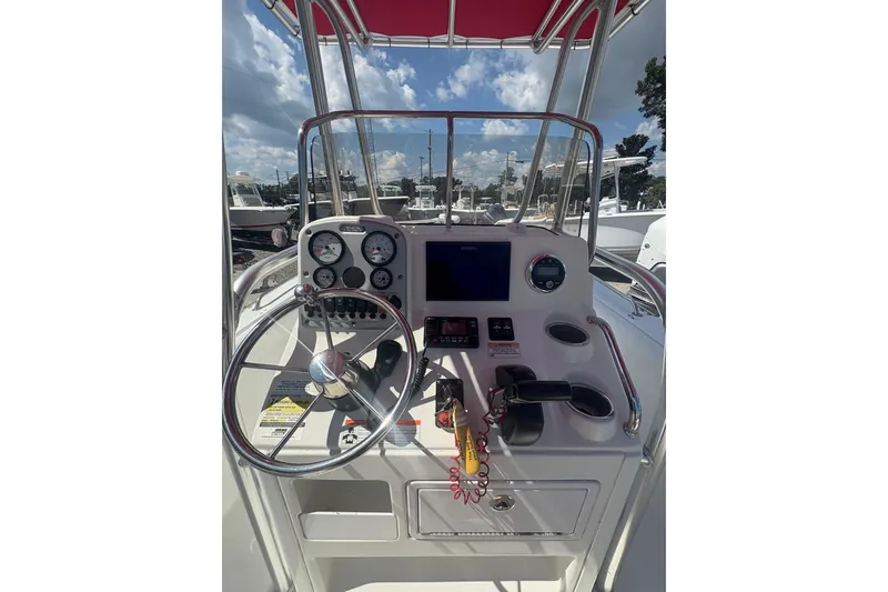 Slide: The Image of 2010 Sea Hunt Triton 202 boat console with steering wheel and gauges under a sunny sky. - 9