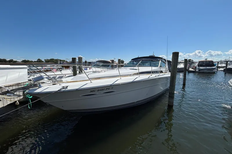 The Image of 1989 Sea Ray 400 Express Cruiser docked at marina under clear blue sky. - 0