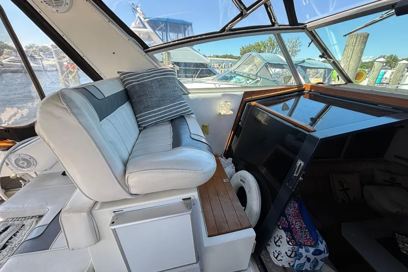 Slide: The Image of 1989 Sea Ray 400 Express Cruiser interior with cushioned seating and nautical decor. - 10