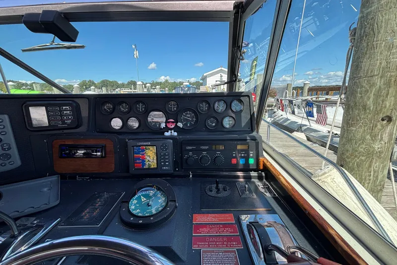 Slide: The Image of Cockpit view of 1989 Sea Ray 400 Express Cruiser with navigation instruments and marina backdrop. - 12