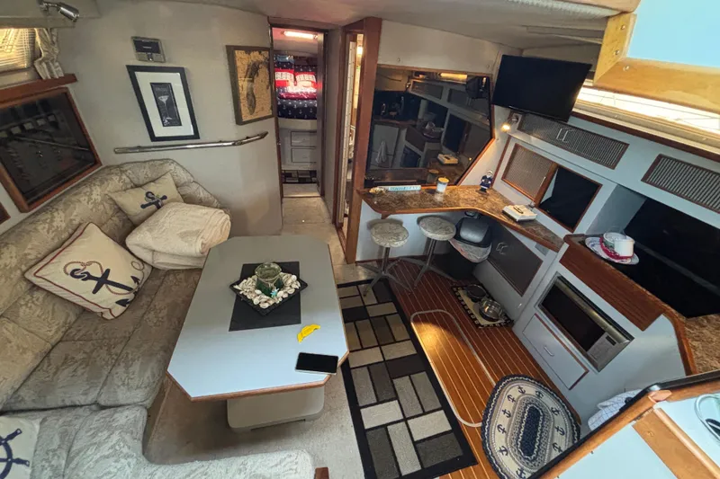 Slide: The Image of 1989 Sea Ray 400 Express Cruiser interior with cozy seating, nautical decor, and modern amenities. - 15