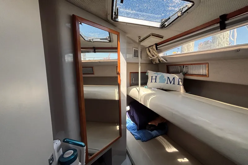 Slide: The Image of 1989 Sea Ray 400 Express Cruiser cabin interior with skylight and cozy bedding. - 20