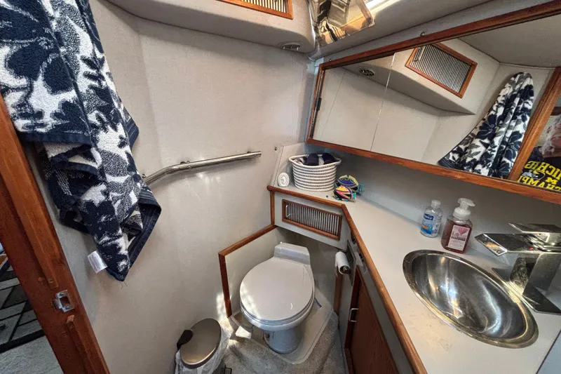 Slide: The Image of 1989 Sea Ray 400 Express Cruiser bathroom with sink, toilet, and storage. - 21