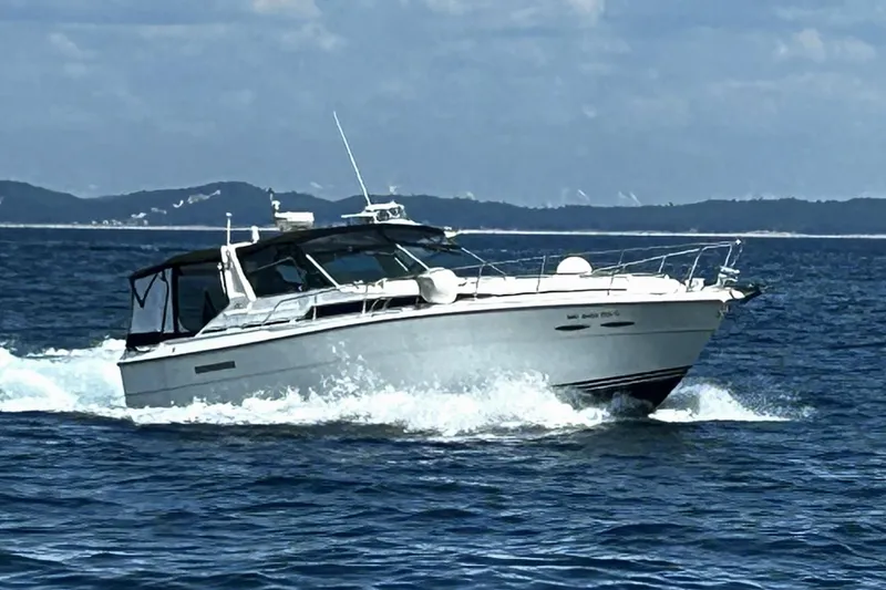 Slide: The Image of 1989 Sea Ray 400 Express Cruiser navigating ocean waves under a clear sky. - 4