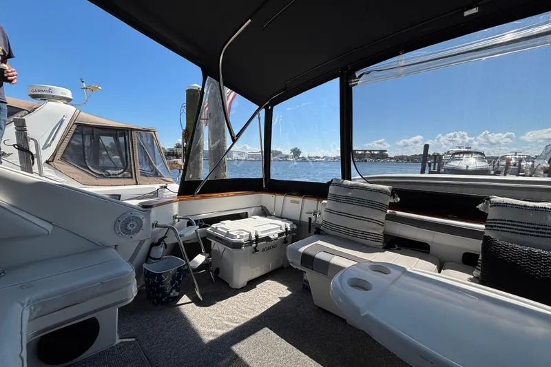 Slide: The Image of 1989 Sea Ray 400 Express Cruiser interior with seating, cooler, and marina view. - 7