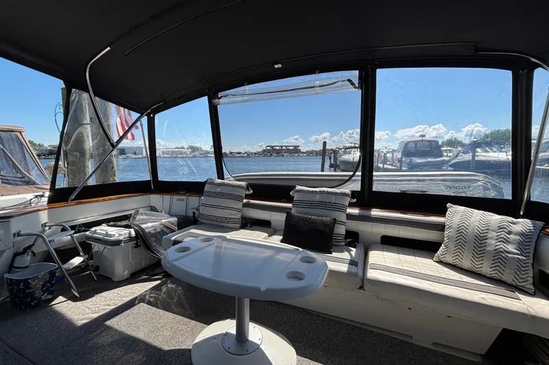 Slide: The Image of 1989 Sea Ray 400 Express Cruiser interior with seating, table, and marina view. - 8
