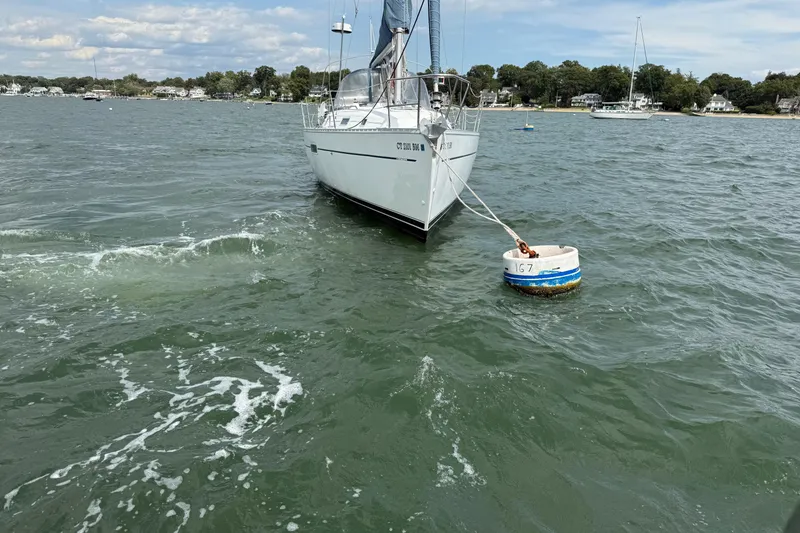 Slide: The Image of 2003 Beneteau Oceanis Clipper 361 sailboat moored on a calm lake with scenic shoreline. - 14