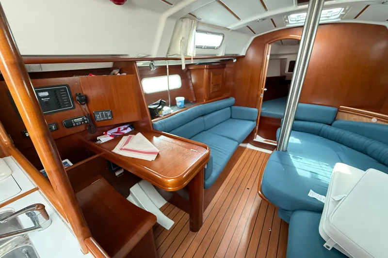 Slide: The Image of Interior of 2003 Beneteau Oceanis Clipper 361 sailboat with wooden finish and blue seating. - 16