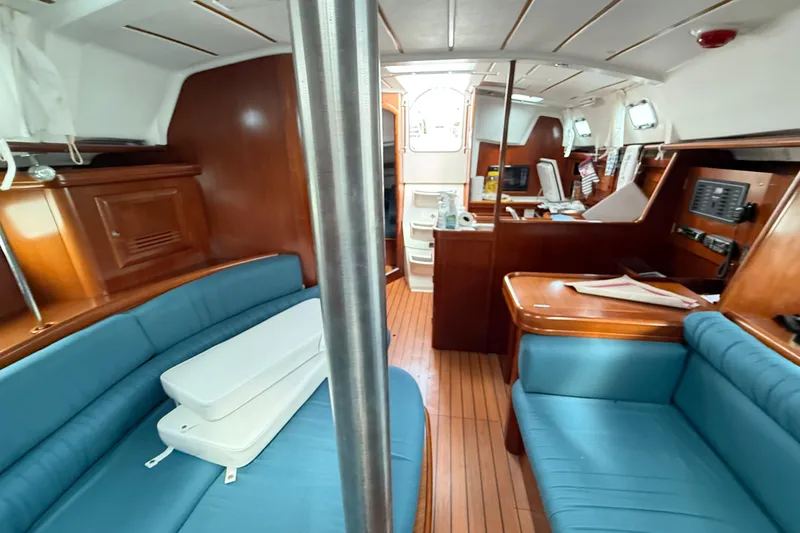 Slide: The Image of Interior of 2003 Beneteau Oceanis Clipper 361 sailboat with blue seating and wooden finishes. - 21