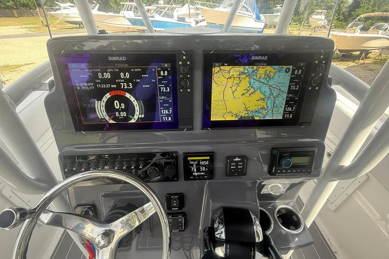 Slide: The Image of 2023 Aquasport 2500 Center Console dashboard with navigation and control systems. - 12