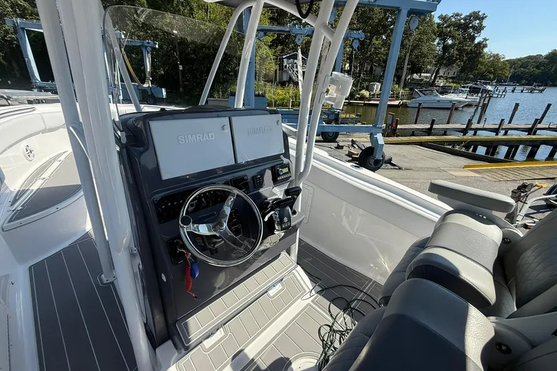 Slide: The Image of 2023 Aquasport 2500 Center Console boat interior with Simrad navigation system. - 13