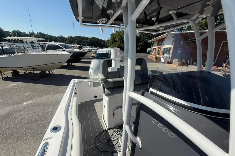 Slide: The Image of 2023 Aquasport 2500 Center Console boat in marina, showcasing sleek design and spacious deck. - 19