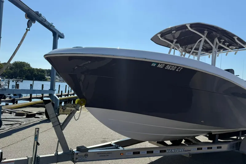 Slide: The Image of 2023 Aquasport 2500 Center Console boat on trailer by waterfront. - 2