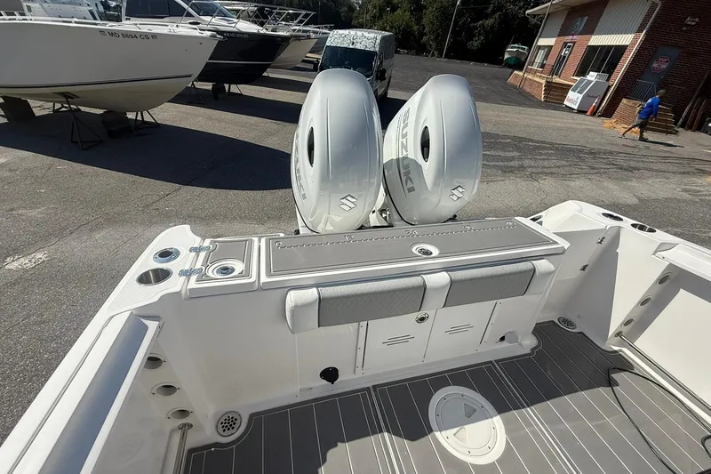 Slide: The Image of 2023 Aquasport 2500 Center Console boat with dual Suzuki engines, docked outdoors. - 20