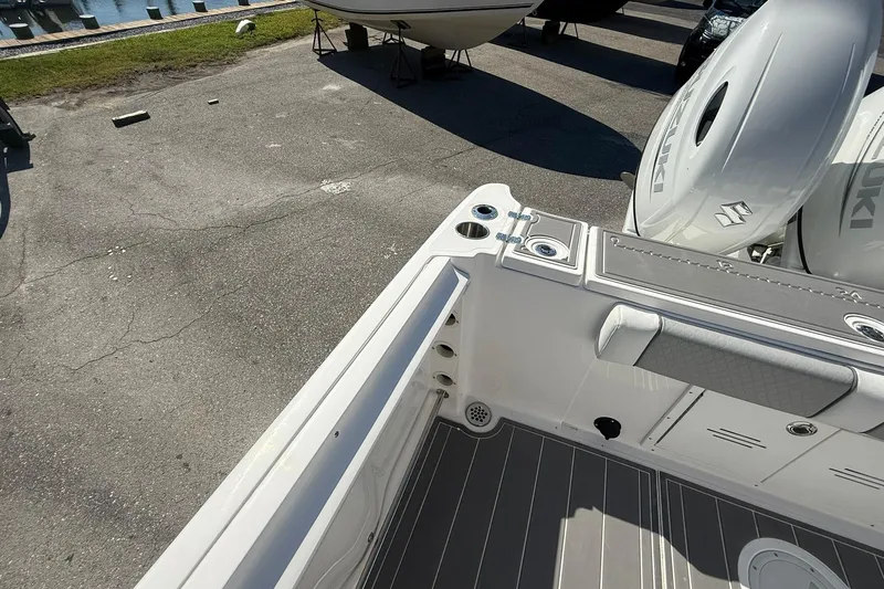 Slide: The Image of 2023 Aquasport 2500 Center Console boat with Suzuki engines, docked on pavement. - 22