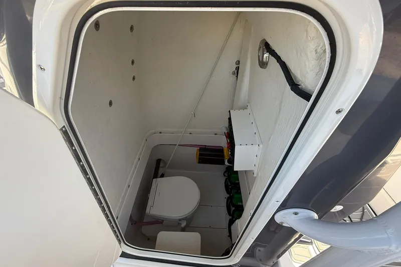 Slide: The Image of 2023 Aquasport 2500 Center Console boat interior with compact marine toilet. - 23