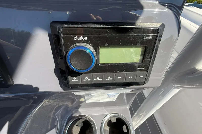 Slide: The Image of Clarion audio system on 2023 Aquasport 2500 Center Console boat dashboard. - 30