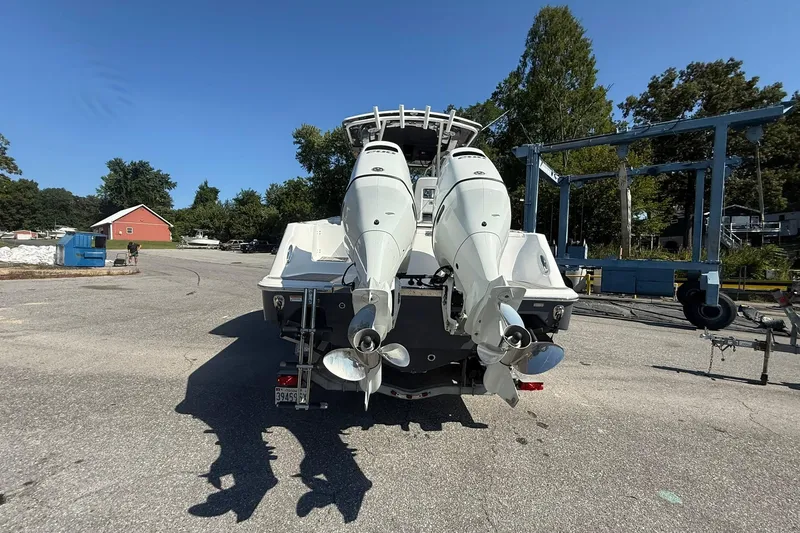 Slide: The Image of 2023 Aquasport 2500 Center Console boat with dual outboard motors in a marina setting. - 9