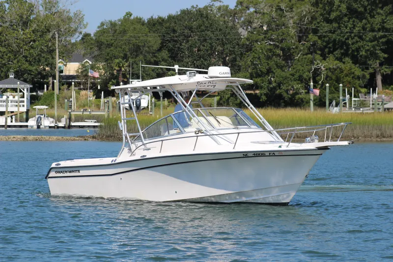 Slide: The Image of 2001 Grady-White Express 265 boat on calm water near a marina. - 1