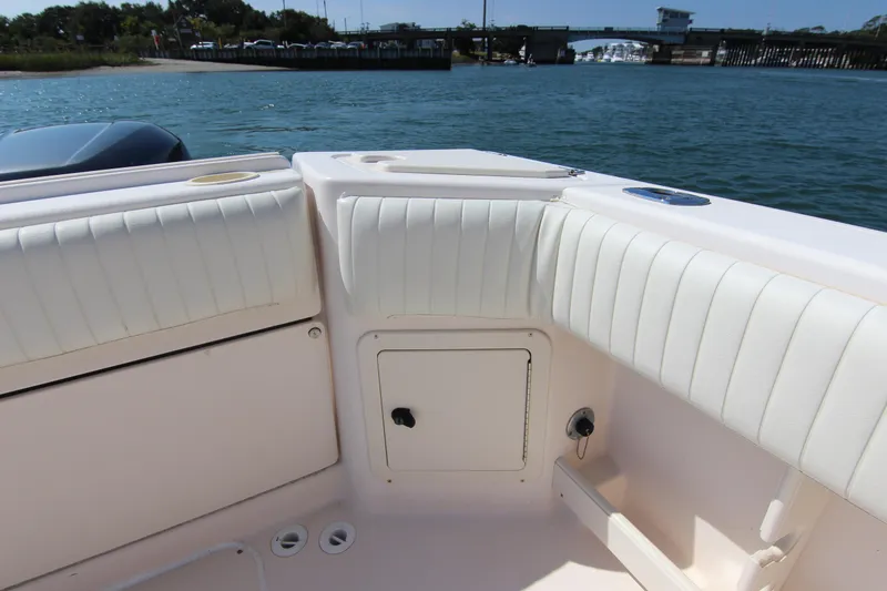 Slide: The Image of 2001 Grady-White Express 265 boat interior with white cushioned seating and storage compartment. - 12