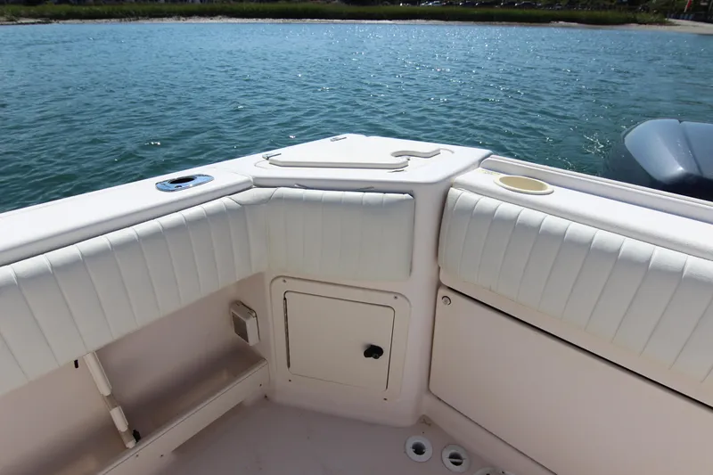 Slide: The Image of 2001 Grady-White Express 265 boat interior with white cushioned seating by the water. - 13