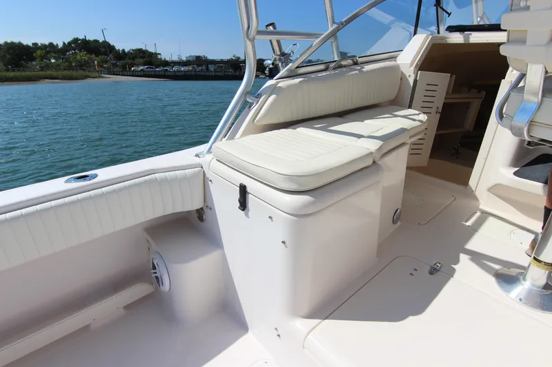 Slide: The Image of 2001 Grady-White Express 265 boat interior with seating and storage, docked by the water. - 14