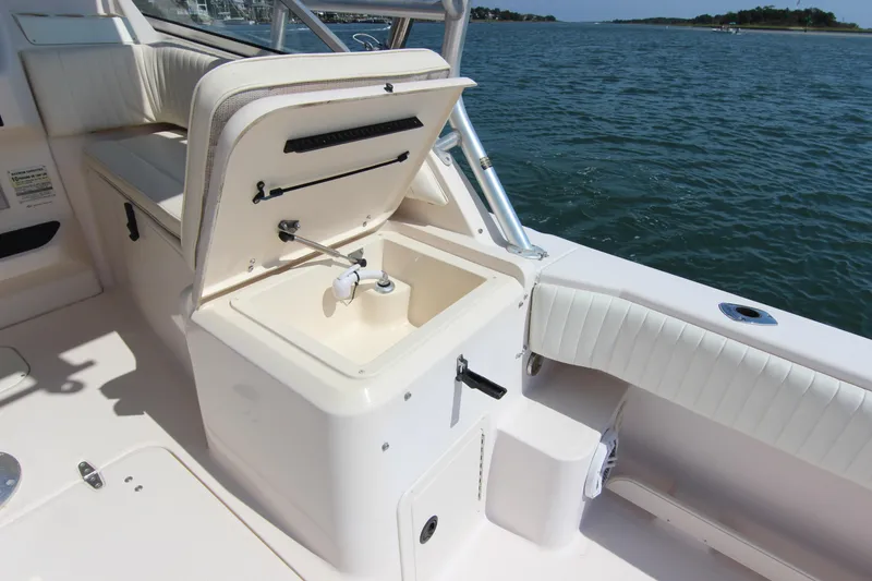 Slide: The Image of 2001 Grady-White Express 265 boat interior with open storage compartment by the water. - 17