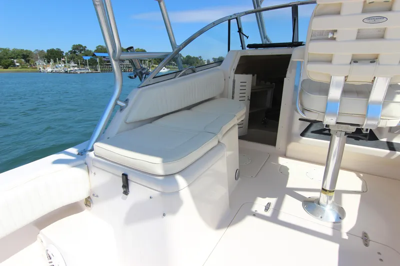 Slide: The Image of 2001 Grady-White Express 265 boat interior with seating and helm, docked by the water. - 19