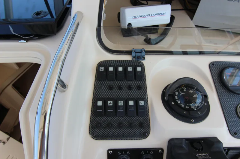Slide: The Image of Control panel of a 2001 Grady-White Express 265 boat with compass and switches. - 21