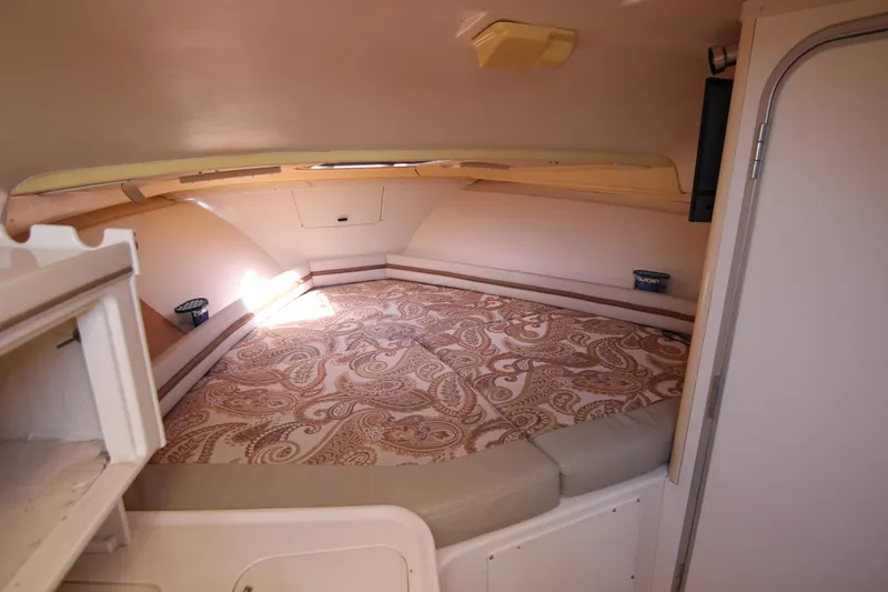 Slide: The Image of 2001 Grady-White Express 265 cabin interior with patterned bedding and storage. - 26