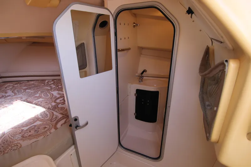 Slide: The Image of 2001 Grady-White Express 265 cabin interior with bed and compact bathroom. - 27