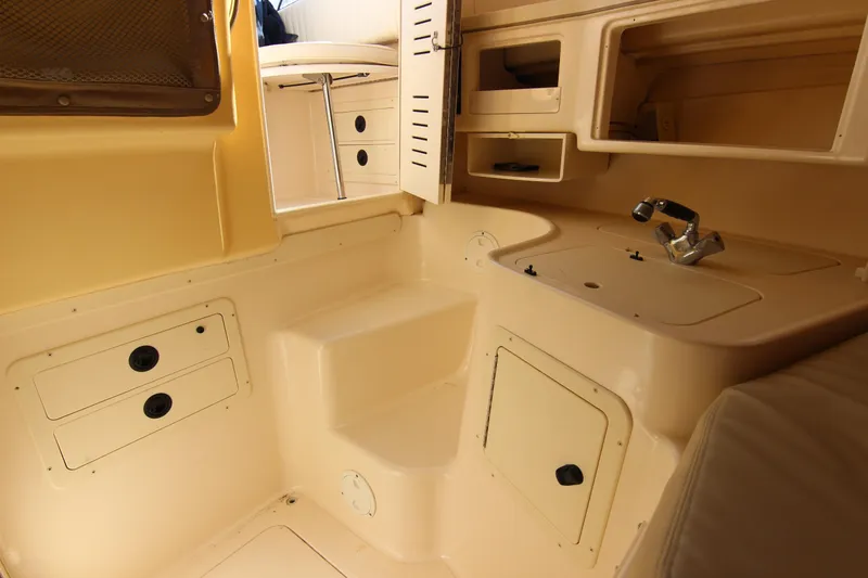 Slide: The Image of Interior of 2001 Grady-White Express 265 boat, featuring compact kitchenette and storage. - 29