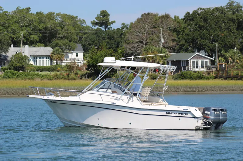 Slide: The Image of 2001 Grady-White Express 265 boat on calm water near shoreline homes. - 6