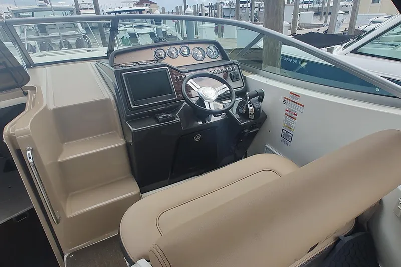 Slide: The Image of 2017 Sea Ray Sundancer 310 helm with steering wheel, gauges, and navigation display. - 20