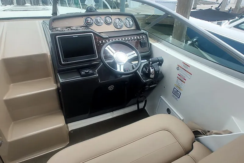 Slide: The Image of 2017 Sea Ray Sundancer 310 helm with steering wheel, gauges, and navigation screen. - 23