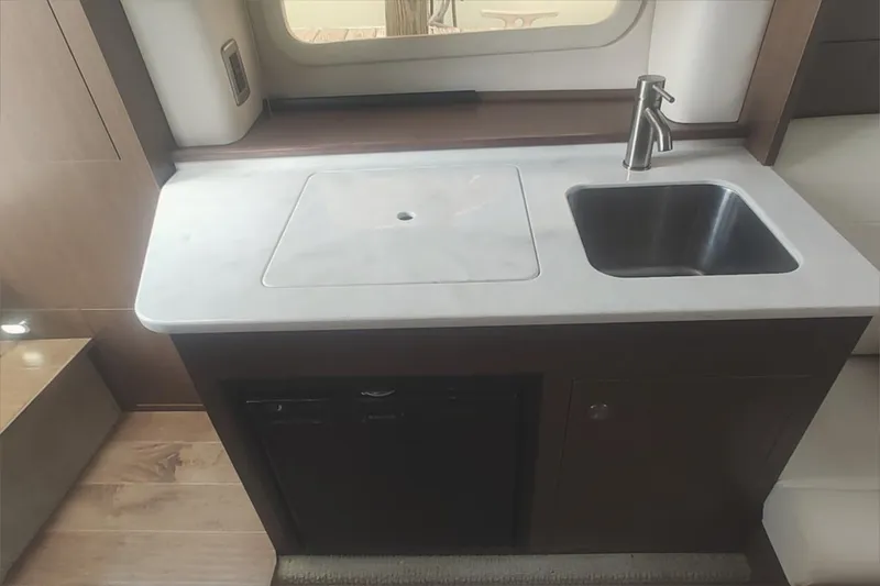 Slide: The Image of Compact kitchen area in 2017 Sea Ray Sundancer 310 with sink and countertop. - 25
