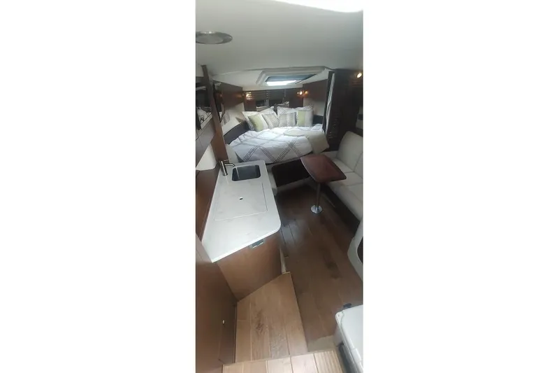 Slide: The Image of 2017 Sea Ray Sundancer 310 interior with cozy bed, kitchenette, and seating area. - 26