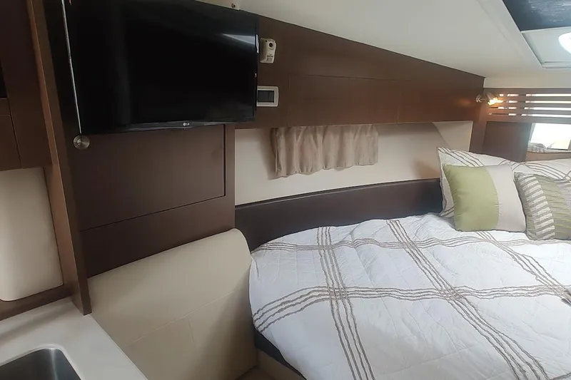 Slide: The Image of 2017 Sea Ray Sundancer 310 cabin interior with bed, TV, and modern decor. - 30