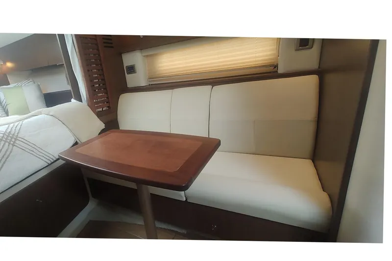 Slide: The Image of Interior of 2017 Sea Ray Sundancer 310 with cozy seating and wooden table. - 33