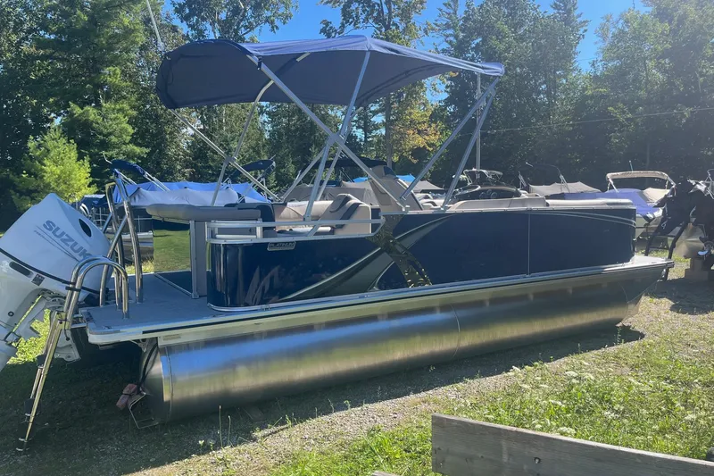The Image of 2026 Avalon 21 LSZ Cruise pontoon boat with Suzuki outboard motor, parked outdoors. - 1