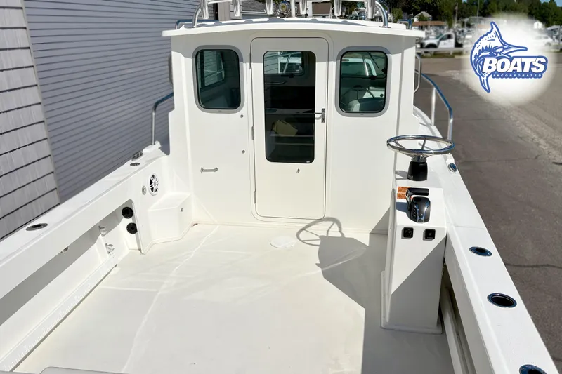 Slide: The Image of 2024 Parker 2320 SL Sport Cabin boat deck with steering console and cabin entrance. - 3