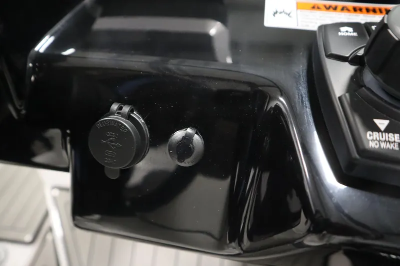 Slide: The Image of Close-up of 2025 Yamaha Boats 252S dashboard with controls and power outlet. - 24