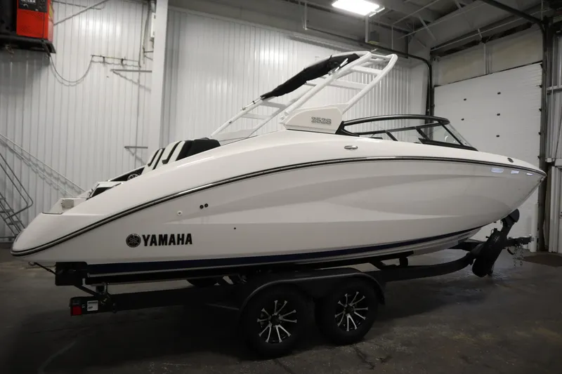 Slide: The Image of 2025 Yamaha Boats 252S in a showroom, sleek white design on a trailer. - 3