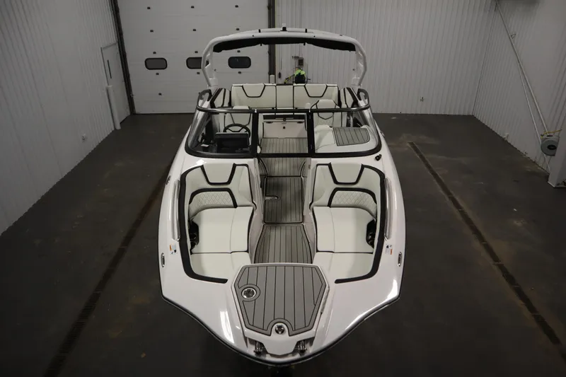 Slide: The Image of 2025 Yamaha Boats 252S, sleek design, spacious interior, white and black accents, indoor showroom. - 8