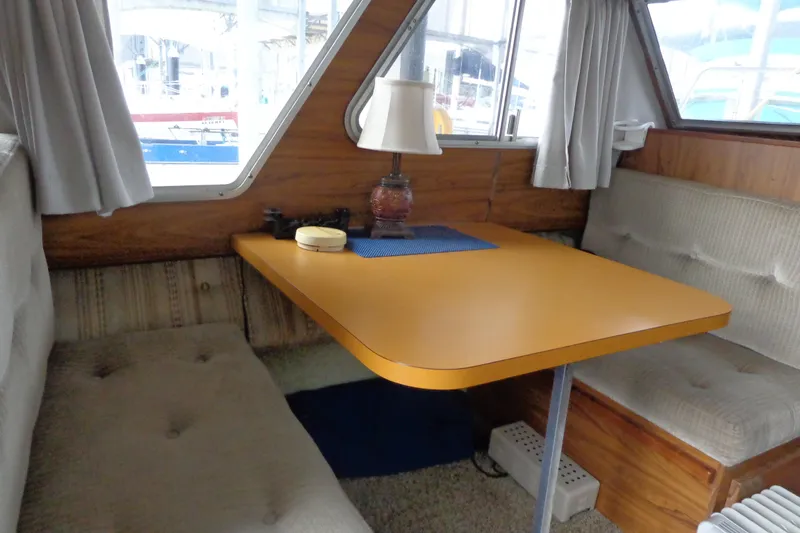 Slide: The Image of Cozy 1976 Tolly sedan interior with a wooden table and cushioned seating. - 11