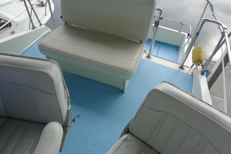 Slide: The Image of Boat interior with white seats and blue flooring, featuring a 1976 Tolly sedan model. - 25