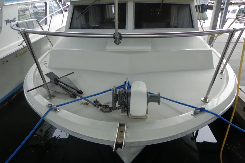 Slide: The Image of Front view of a docked boat with anchor and ropes, featuring a 1976 Tolly sedan. - 5